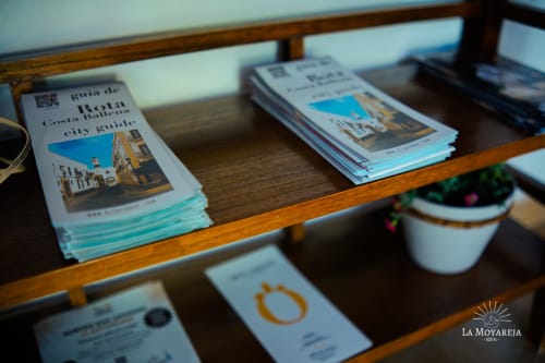 Mostrador de recepción del Hostal La Moyareja con guías turísticas y material informativo de la ciudad de Rota, España