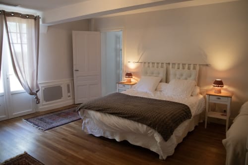 Chambre élégante du Domaine de Castagnère avec lit queen-size, mobilier crème, parquet et éclairage tamisé