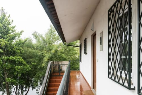 Balcony terrace at Voluta Management B&B in Chaves, Portugal with stairs and forest views