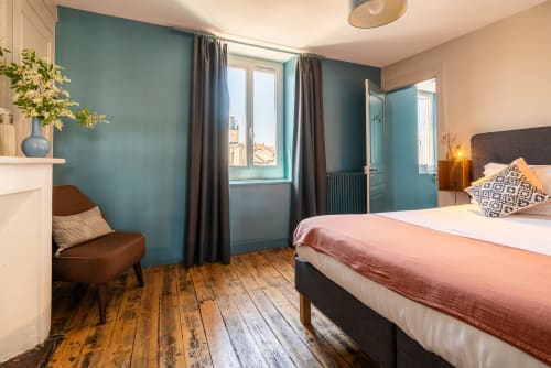Chambre lumineuse au Gîte Dupain & Dubeurre à Limoges avec murs bleu-vert, parquet et vue sur jardin