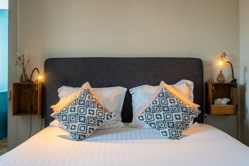 Chambre moderne de l'appartement Kersauson au B&B Dupain & Dubeurre à Limoges, avec tête de lit foncée et coussins motifs