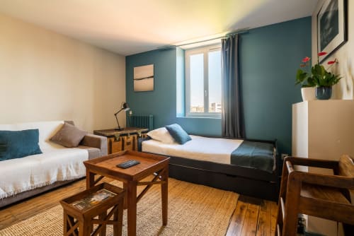 Chambre de l'appartement Kersauson au B&B Dupain & Dubeurre à Limoges avec lit jumeaux, canapé et mobilier en bois