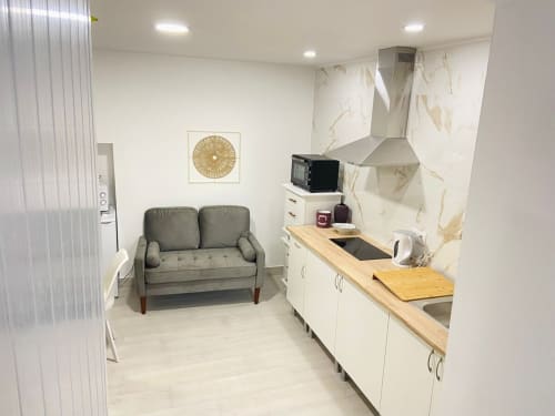 Apartamento estúdio moderno em Peniche com kitchenette, sofá cinzento, painel de mármore e área de refeições