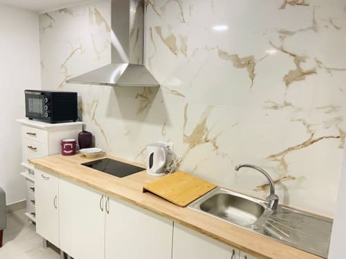 Cozinha moderna no apartamento Casa das 7 Janelas, Peniche, com backsplash em mármore, pia em aço inoxidável e bancada em madeira