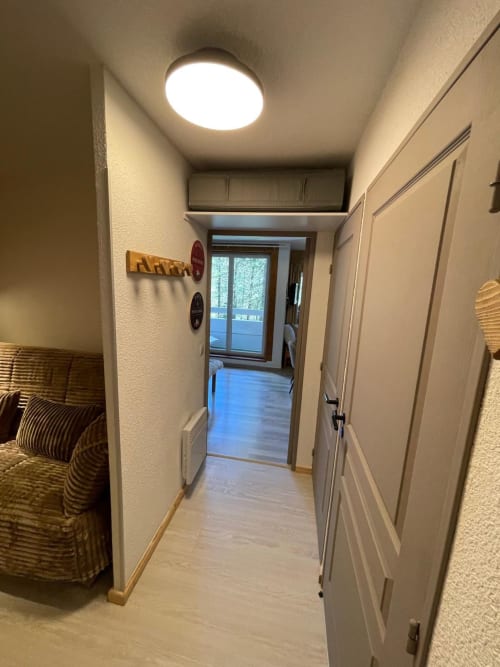 Couloir d'un appartement 4/5 personnes à GNM, Vars, aux murs blancs, sol en bois et éclairage plafonnier