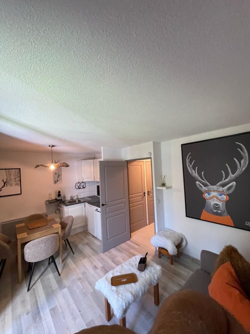 Appartement moderne à GNM Vars avec séjour ouvert intégrant cuisine, salle à manger et salon orné d'œuvres de cerf