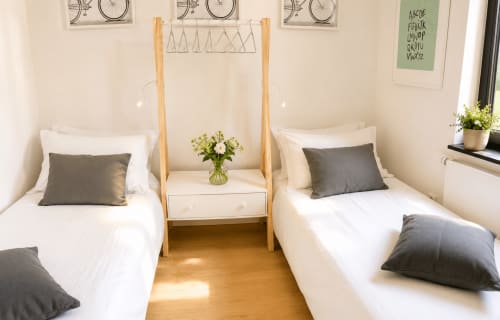 Chambre twin de l'appartement Mattbnb La Petrussina, Luxembourg avec lits blancs, oreillers gris, table de nuit partagée et frais