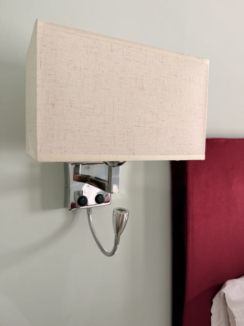 Lámpara de lectura montada en pared con pantalla de lino crema en habitación del hotel Edificio San Esteban 16, Sevilla