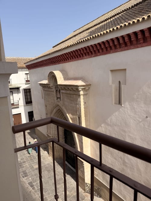 Vista de balcón del patio histórico con tejadillos y arquitectura medieval en apartamento de hotel en Sevilla