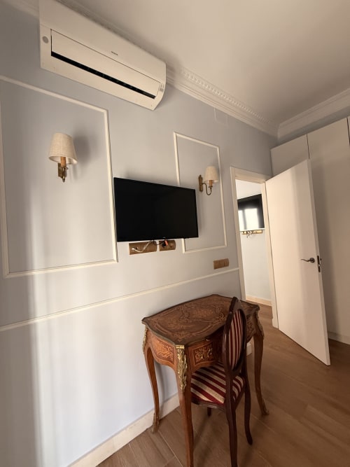 Elegante suite de hotel en Edificio San Esteban 16, Sevilla, con escritorio, TV mural, muebles de época y aire acondicionado moderno