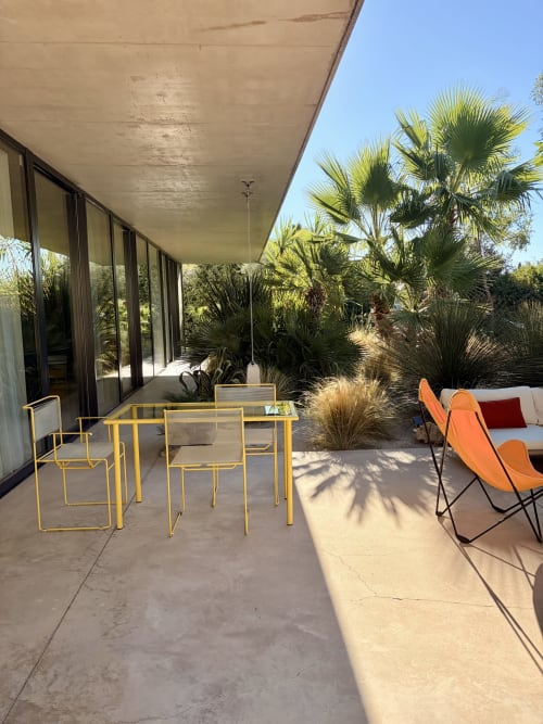 Patio de la Maison Jalon avec chaises jaunes, palmiers et bâtiment moderne à Aix-en-Provence