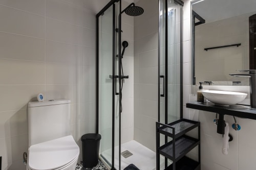 Baño moderno en G&H Apartments de Jerez de la Frontera con ducha abierta, inodoro y lavabo tipo vessel con accesorios negros