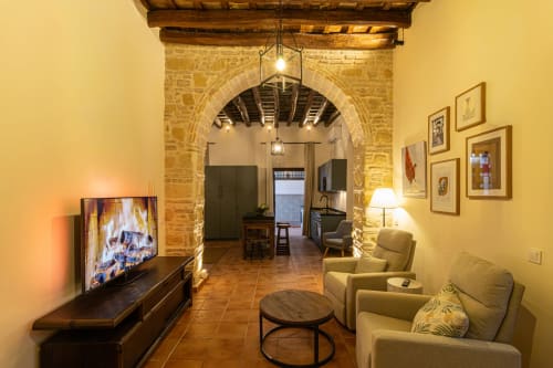 Acogedora sala de estar en el apartamento Casa Haurie, Jerez de la Frontera, con arco de piedra, chimenea con TV y cómodos asientos