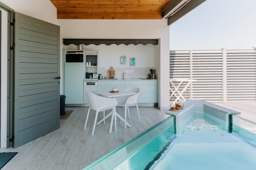 Cabane de piscine moderne à l'Habitation l'SEO à Sainte-Anne avec kitchenette, coin repas et piscine turquoise.