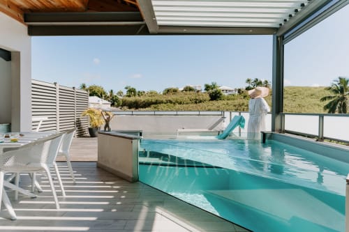Terrasse piscine à débordement du Habitation I'SEO à Sainte-Anne avec vue tropicale luxuriante et transats