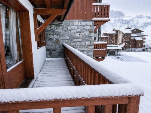 Balcon alpin enneigé du Chalet des Cimes, Belle Plagne, avec vue sur les montagnes et chalets en bois