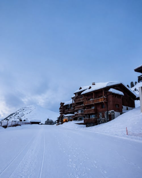 Le Chalet des Cimes à Belle Plagne, refuge alpin en bois dans un paysage enneigé avec vue sur les montagnes