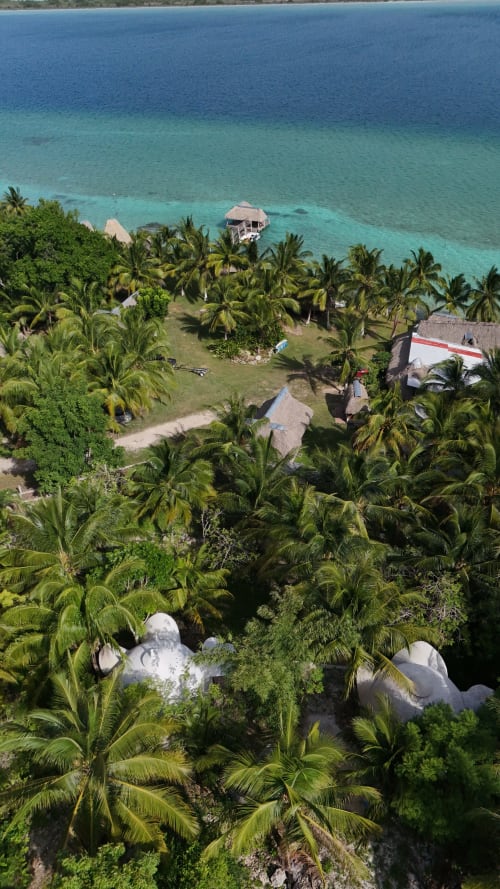 Vista aérea del hostal Cayuco Maya en Bacalar con domos geodésicos, palmeras, laguna turquesa y kayaks