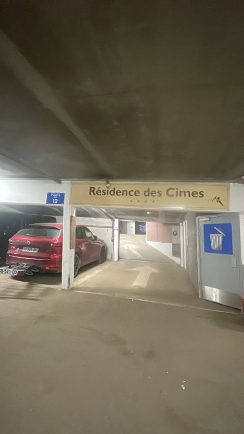 Entrée du parking souterrain de la Résidence des Cimes, Belle Plagne avec voiture rouge et panneau port 12