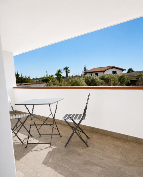 Terrasse avec table et chaises offrant une vue sur les oliviers et la campagne à la B&B Helios, Nardò