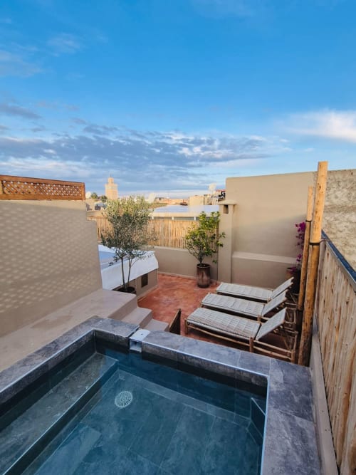 Terrasse sur le toit du Riad Casa Angelo à Marrakech avec piscine, transats et vue sur la médina
