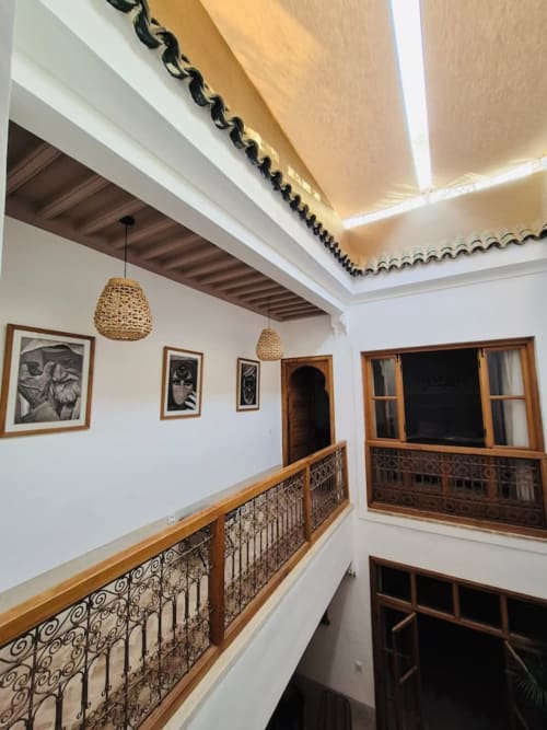 Cour intérieure du Riad Casa Angelo à Marrakech avec balustrades en bois traditionnel, murs blancs et plafond voûté