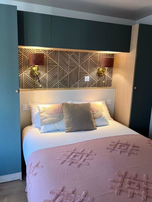 Chambre moderne aux Logis du canal à Betton avec lit queen-size, tête de lit géométrique et rangements noirs