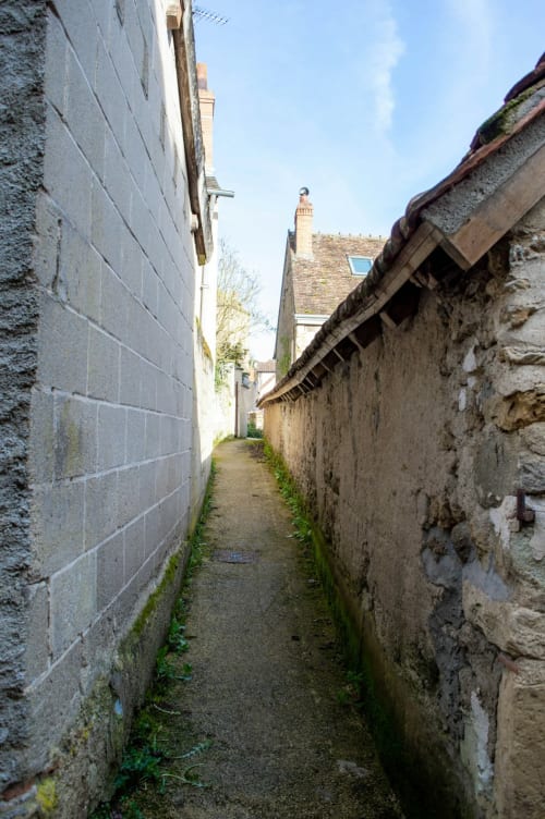 Ruelle étroite en pierre entre les bâtiments aux Logis du Canal à Betton, France