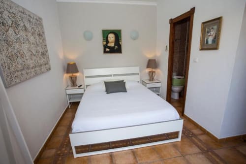 Moderno dormitorio doble en Hotelito Oliva con cama blanca, lámparas de noche y acceso al baño en Oliva, España