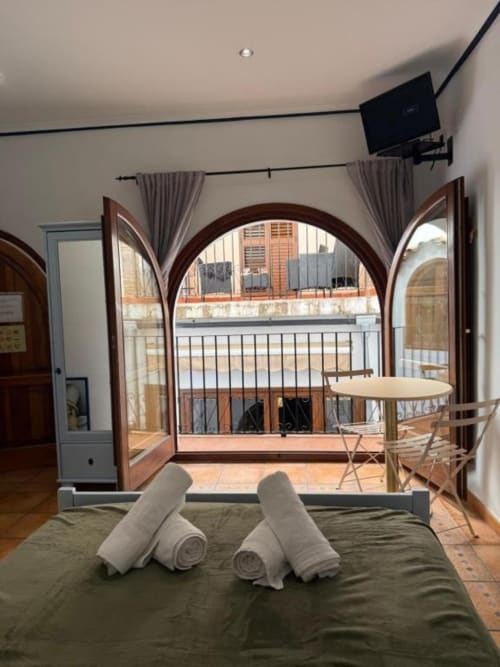 Habitación moderna del Hotelito Oliva con puertas arqueadas que se abren a un balcón con vistas a Oliva, España