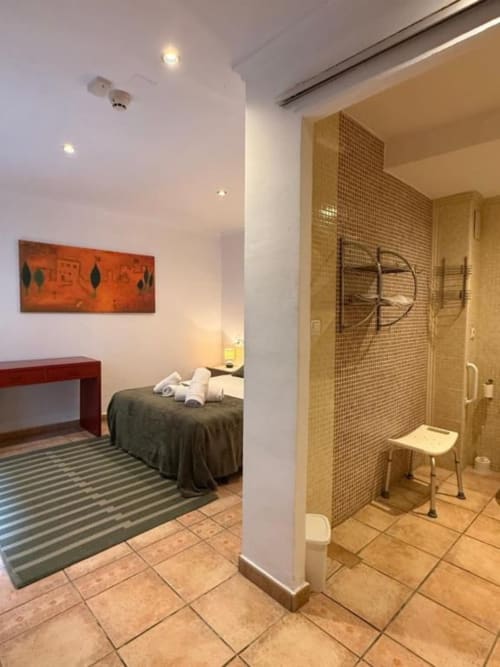 Habitación moderna en Hotelito Oliva con cama, baño privado con ducha alicatada y mobiliario contemporáneo en Oliva