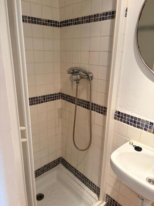 Moderno baño con azulejos blancos y borde negro en Hotelito Oliva Pensión, Oliva, España