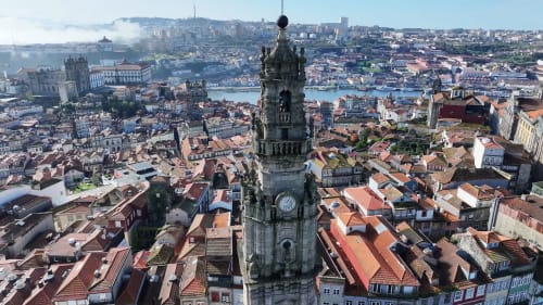 Torre histórica com vista para os edifícios de telhado em terracota de Maia e o rio no Porto, Portugal
