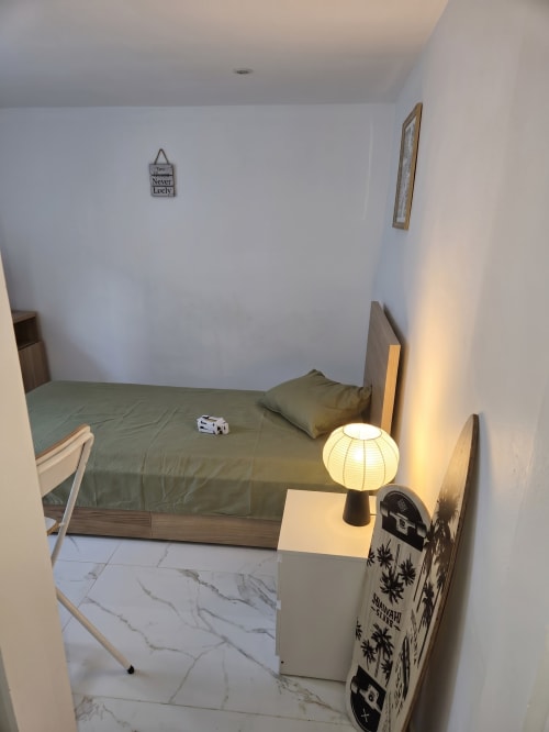Quarto minimalista no Boeing AL hotel em Moreirada Maia com roupa de cama olive, luminária pendente e decoração de parede