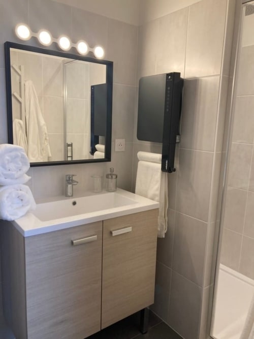 Salle de bain moderne au Relais de Touraine avec vasque, miroir éclairant et douche à Abilly