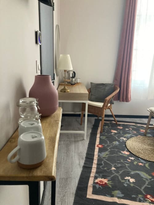 Chambre d'hôtel au Relais de Touraine à Abilly avec bureau, chaise, vase décoratif et tapis à motifs floraux