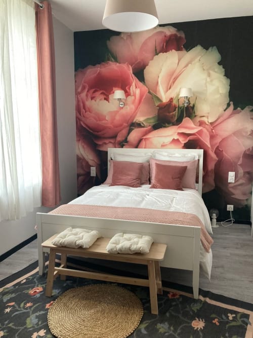 Chambre élégante au Relais de Touraine avec fresque murale florale rose, lit blanc, accents roses et banc en bois