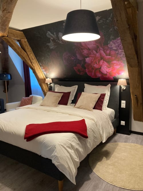 Chambre élégante à l'hôtel Le relais de Touraine à Abilly avec literie crème, touches bourgogne et œuvre florale au-dessus du lit