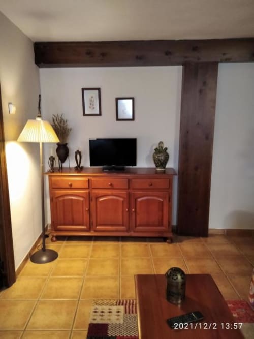 Estudio Casa Lahuerta en Bronchales con muebles de barro, TV de pantalla plana, vigas de madera y piso de baldosas