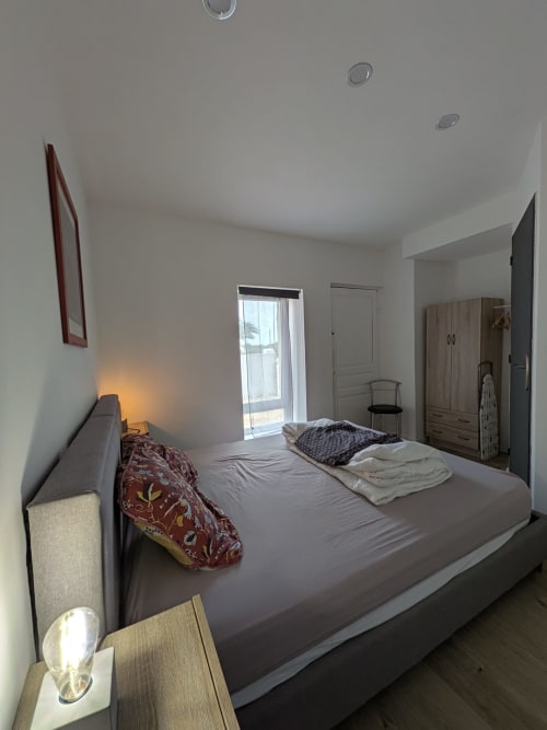 Chambre lumineuse à la Résidence des dunes à Landéda avec lit queen-size, armoire et accès balcon par porte vitrée