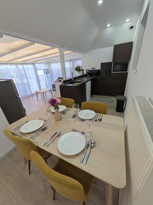 Salle à manger moderne avec table dressée et chaises jaunes à la Résidence des dunes à Landéda, France