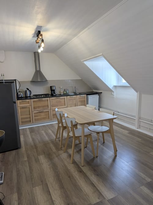Cuisine-salle à manger d'appartement mansardé moderne à la Résidence des dunes, Landéda avec mobilier en bois et puits de lumière