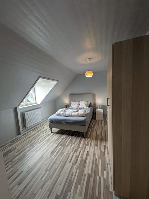 Chambre mansardée moderne à la Résidence des dunes à Landéda avec lit, lucarne, suspension et sol à rayures