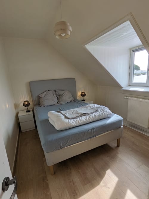 Chambre lumineuse sous les combles à la Résidence des dunes avec lit gris, velux, suspension et parquet à Landéda