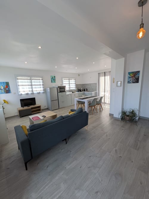 Appartement moderne en open-space à la Résidence des dunes à Landéda avec cuisine, coin repas, séjour avec TV et vue sur le jardin