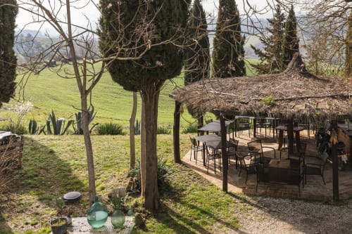 Terrazza giardino toscano con zona pranzo, cipressi e vista sulla campagna verdeggiante presso hotel vicino a Buonconvento