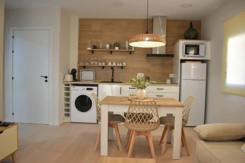 Cocina-comedor moderno en apartamento Casa El Abuelo, Bronchales, con lavadora, refrigerador, mesa de comedor y acabados de madera