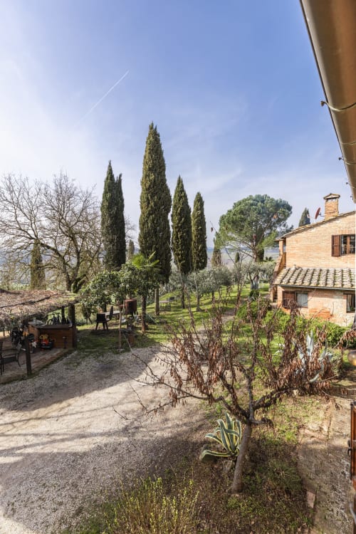 Villa toscana circondata da cipressi, edifici in cotto e giardini a Buonconvento