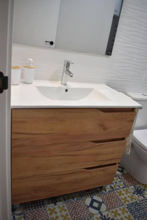Vanitory moderno con lavabo blanco, canilla cromada y cajones de madera en apartamento Casa El Abuelo