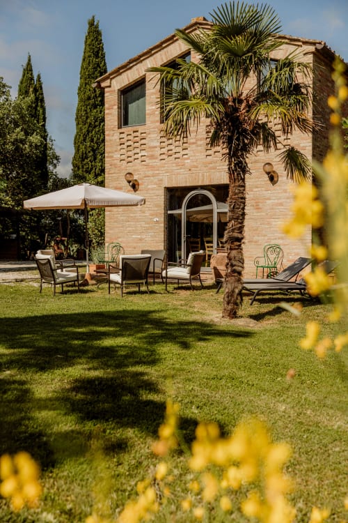 Villa in mattoni con terrazza arredata, palma e giardino curato a Buonconvento, Toscana